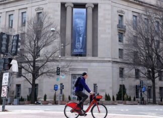 Jurnaliștii americani au comparat bannerul cu chipul lui Trump de la DOJ cu decorul unui discurs faimos din 1989 al autocratului român Nicolae Ceaușescu, care a mințit fără rușine poporul pentru ultima dată.